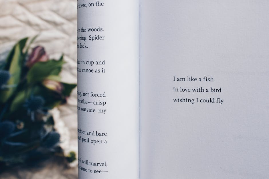 An open book with a poetic quote next to blurred flowers on a rustic surface.